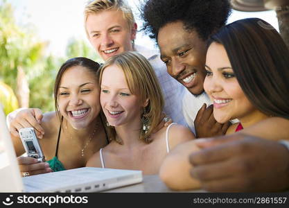 Friends Using Cell Phone and Laptop