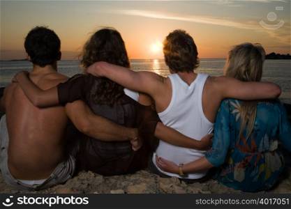 Friends watching the sunset by sea