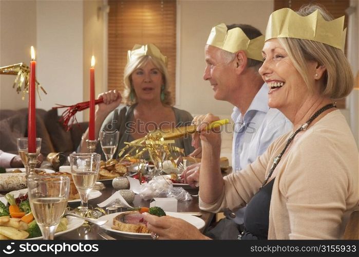 Friends Wearing Party Hats At A Dinner Party
