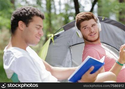 friends with different leisure at campsite