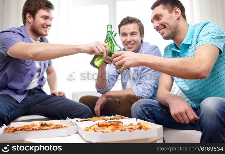 friendship, alcohol, people, celebration and holidays concept - close up of happy male friends clinking beer bottles and eating pizza at home
