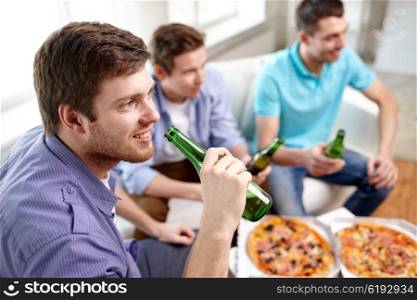 friendship, alcohol, people, celebration and holidays concept - close up of happy male friends clinking beer bottles and eating pizza at home