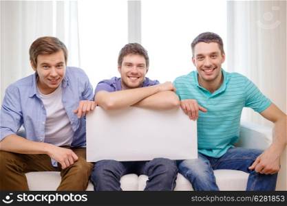 friendship and advertising concept - smiling male friends holding white blank board