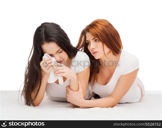 friendship and happy people concept - one teenage girl comforting another after break up