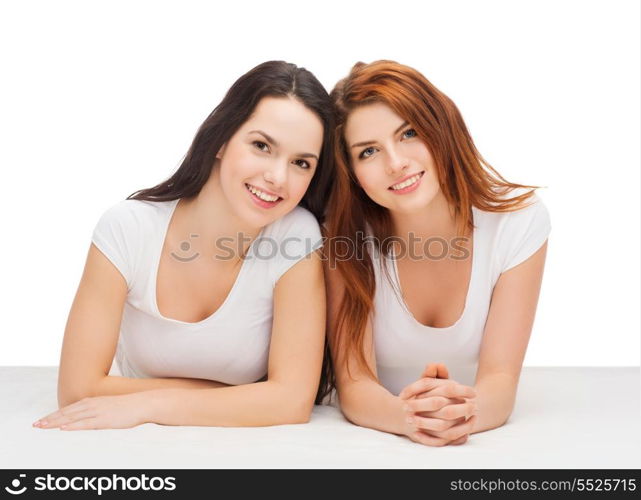 friendship and happy people concept - two laughing girls in white t-shirt