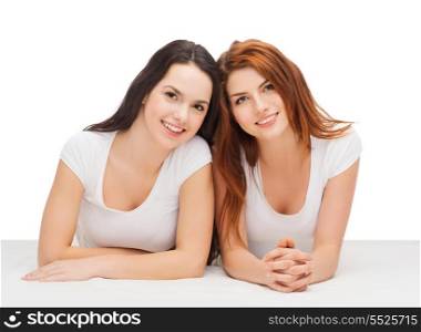 friendship and happy people concept - two laughing girls in white t-shirt