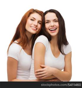 friendship and happy people concept - two laughing girls in white t-shirt hugging