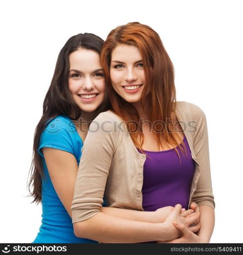 friendship and happy people concept - two smiling girls hugging