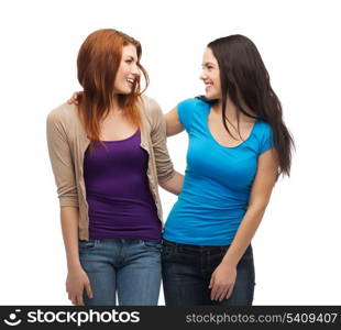 friendship and happy people concept - two smiling girls looking at each other