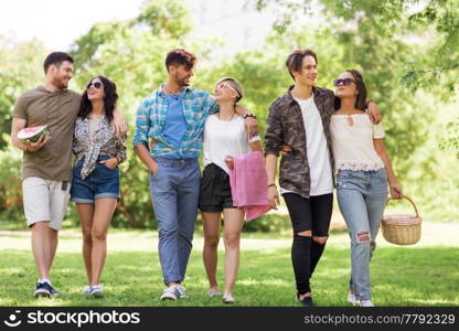 friendship and leisure concept - group of happy friends with picnic blanket and watermelon walking at summer park. happy friends with picnic blanket at summer park