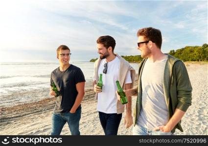 friendship and leisure concept - group of happy young men or male friends toasting non alcoholic beer walking along summer beach. young men with non alcoholic beer walking on beach