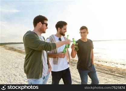 friendship and leisure concept - group of happy young men or male friends toasting non alcoholic beer on summer beach. young men toasting non alcoholic beer on beach