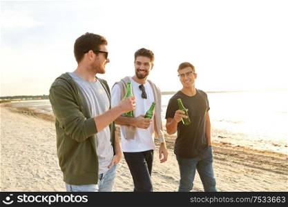 friendship and leisure concept - group of happy young men or male friends toasting non alcoholic beer on summer beach. young men toasting non alcoholic beer on beach