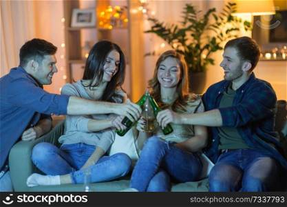 friendship, and leisure concept - happy friends watching tv and clinking non-alcoholic drinks at home in evening. friends clinking drinks at home in evening