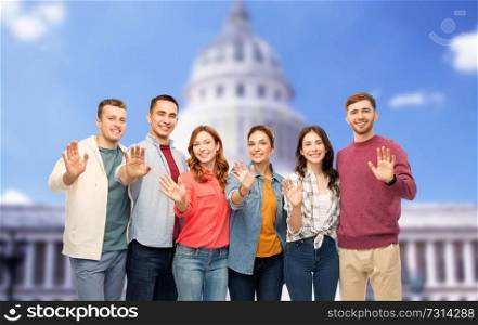 friendship and people concept - group of smiling friends over capitol building background. group of smiling friends over capitol building