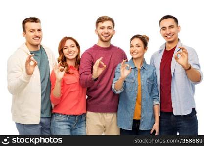 friendship and people concept - group of smiling friends showing ok hands sign over white background. group of smiling friends showing ok hands sign