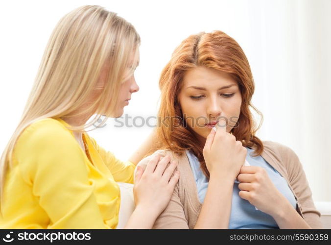 friendship and people concept - one teenage girl comforting another after break up