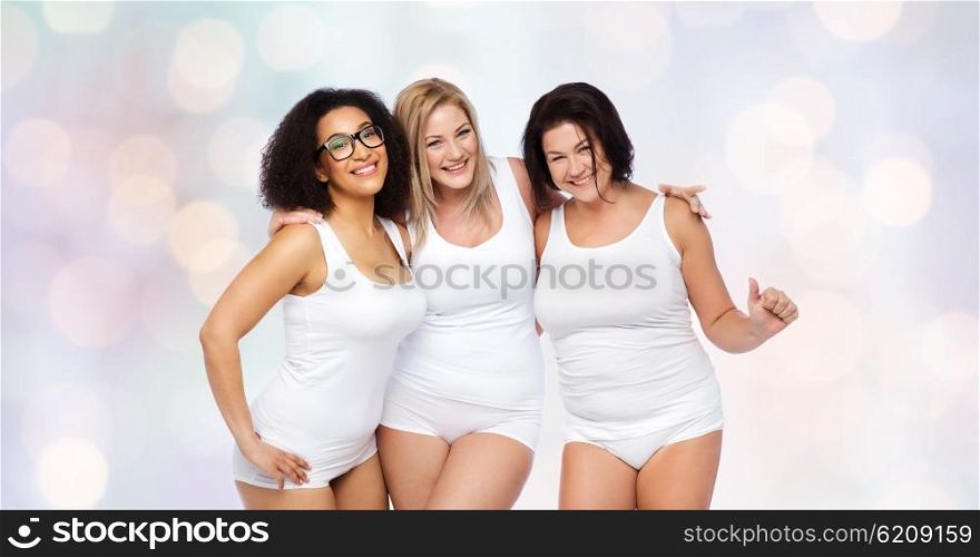 friendship, beauty, body positive and people concept - group of happy plus size women in white underwear over holidays lights background