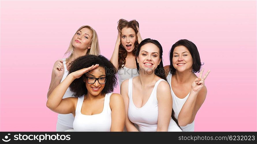 friendship, beauty, body positive and people concept - group of happy plus size women in white underwear having fun and making faces over pink background