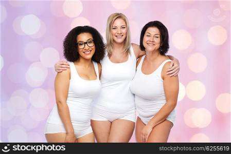 friendship, beauty, body positive and people concept - group of happy plus size women in white underwear over rose quartz and serenity lights background