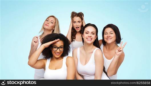 friendship, beauty, body positive and people concept - group of happy plus size women in white underwear having fun and making faces over blue background