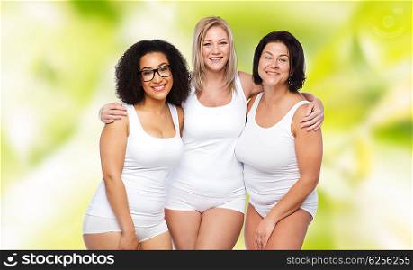 friendship, beauty, body positive and people concept - group of happy plus size women in white underwear over green natural background