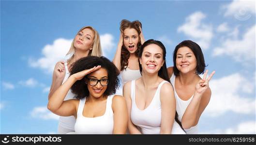 friendship, beauty, body positive and people concept - group of happy plus size women in white underwear having fun and making faces over blue sky and clouds background