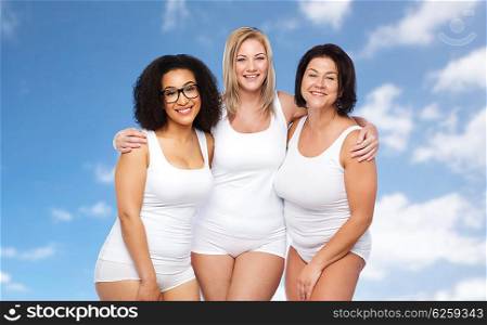 friendship, beauty, body positive and people concept - group of happy plus size women in white underwear over blue sky and clouds background