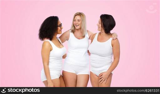 friendship, beauty, body positive and people concept - group of happy plus size women in white underwear over pink background