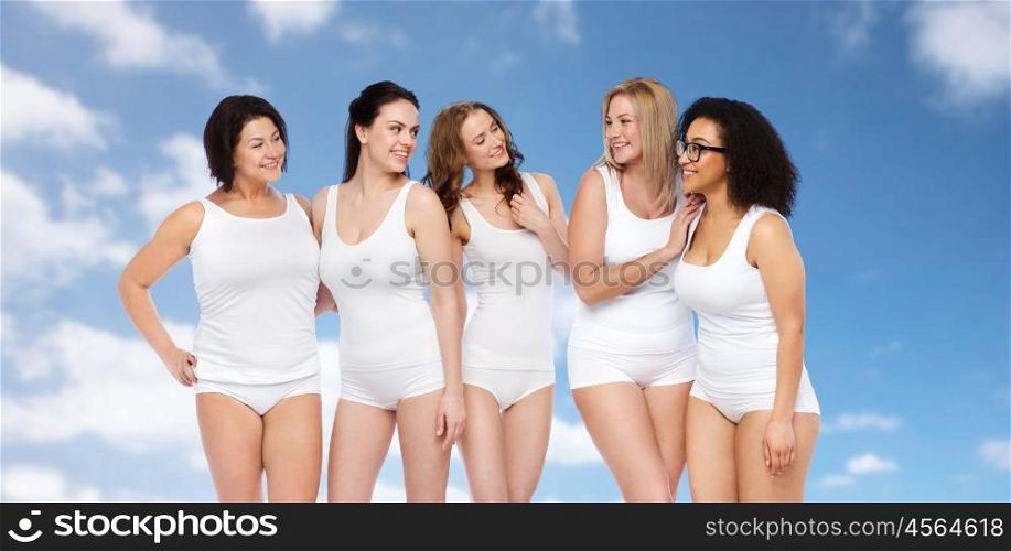 friendship, beauty, body positive and people concept - group of happy women different in white underwear over blue sky and clouds background. group of happy different women in white underwear