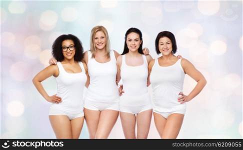 friendship, beauty, body positive and people concept - group of happy women different in white underwear over holidays lights background