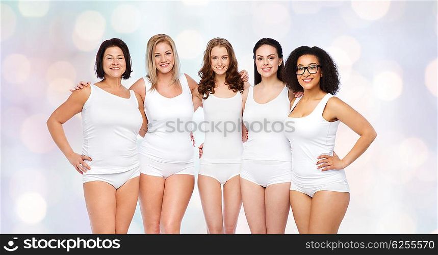 friendship, beauty, body positive and people concept - group of happy women different in white underwear over holidays lights background