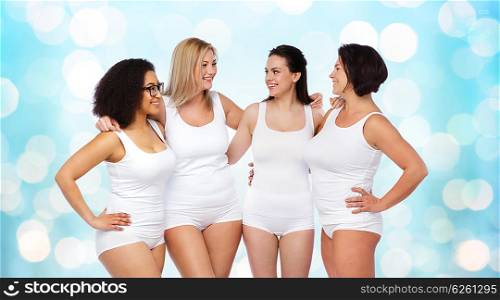 friendship, beauty, body positive and people concept - group of happy women different in white underwear over blue holidays lights background