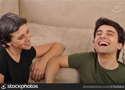 friendship between sister and brother lying and laughing on the floor next to couch