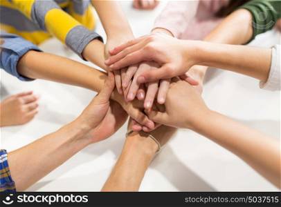 friendship, childhood and people concept - group of kinds with hands on top. group of kinds with hands on top