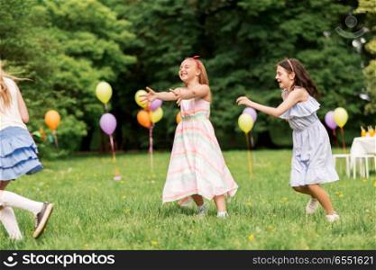 friendship, childhood, leisure and people concept - group of happy girls or friends playing tag game at birthday party in summer park. happy girls playing tag game at birthday party. happy girls playing tag game at birthday party
