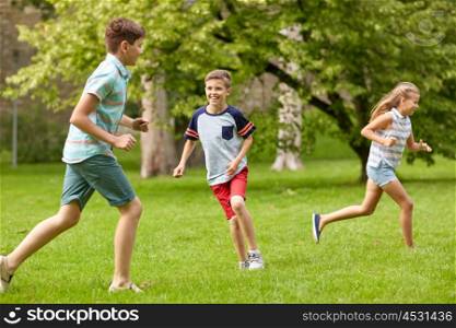 friendship, childhood, leisure and people concept - group of happy kids or friends playing catch-up game and running in summer park