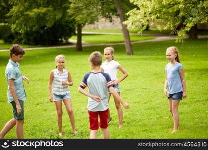 friendship, childhood, leisure and people concept - group of happy kids or friends playing game in summer park