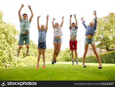 friendship, childhood, leisure and people concept - group of happy kids or friends jumping up and having fun in summer park