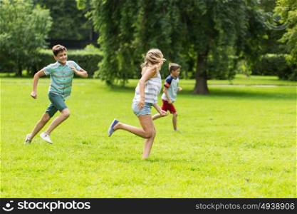 friendship, childhood, leisure and people concept - group of happy kids or friends playing catch-up game and running in summer park. group of happy kids or friends playing outdoors