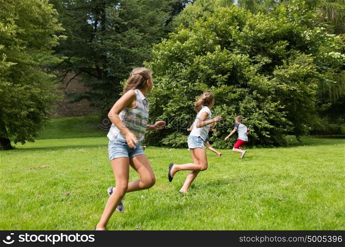 friendship, childhood, leisure and people concept - group of happy kids or friends playing catch-up game and running in summer park. group of happy kids or friends playing outdoors