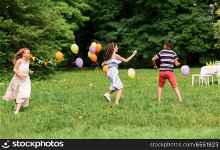 friendship, childhood, leisure and people concept - group of happy kids or friends playing tag game at birthday party in summer park. happy kids playing tag game at birthday party. happy kids playing tag game at birthday party