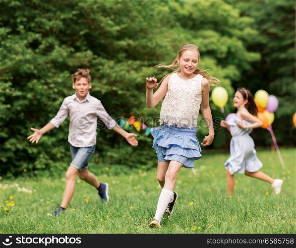 friendship, childhood, leisure and people concept - group of happy kids or friends playing tag game at birthday party in summer park. happy kids playing tag game at birthday party