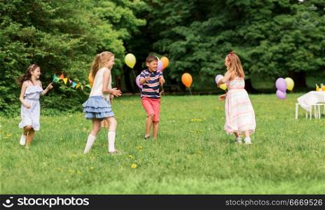 friendship, childhood, leisure and people concept - group of happy kids or friends playing tag game at birthday party in summer park. happy kids playing tag game at birthday party. happy kids playing tag game at birthday party