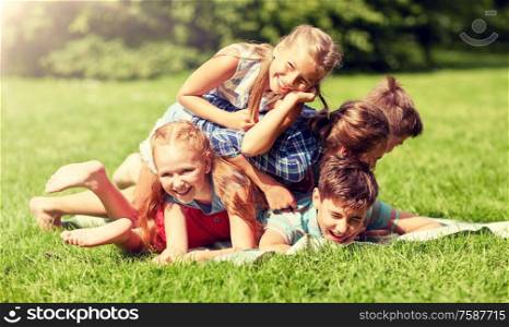 friendship, childhood, leisure and people concept - group of happy kids or friends playing and having fun in summer park. happy kids playing and having fun in summer park