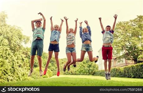 friendship, childhood, leisure and people concept - group of happy kids or friends jumping up and having fun in summer park. happy kids jumping and having fun in summer park