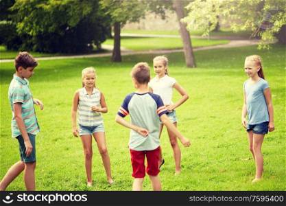 friendship, childhood, leisure and people concept - group of happy kids or friends playing game in summer park. happy kids playing game in summer park