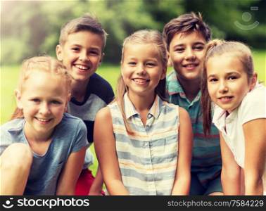 friendship, childhood, leisure and people concept - group of happy kids or friends in summer park. group of happy kids or friends outdoors