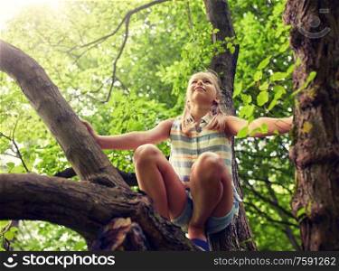 friendship, childhood, leisure and people concept - happy girl climbing up tree and having fun in summer park. happy girl climbing up tree in summer park