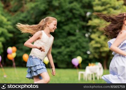 friendship, childhood, leisure and people concept - happy girls or friends playing tag game at birthday party in summer park. happy girls playing tag game at birthday party